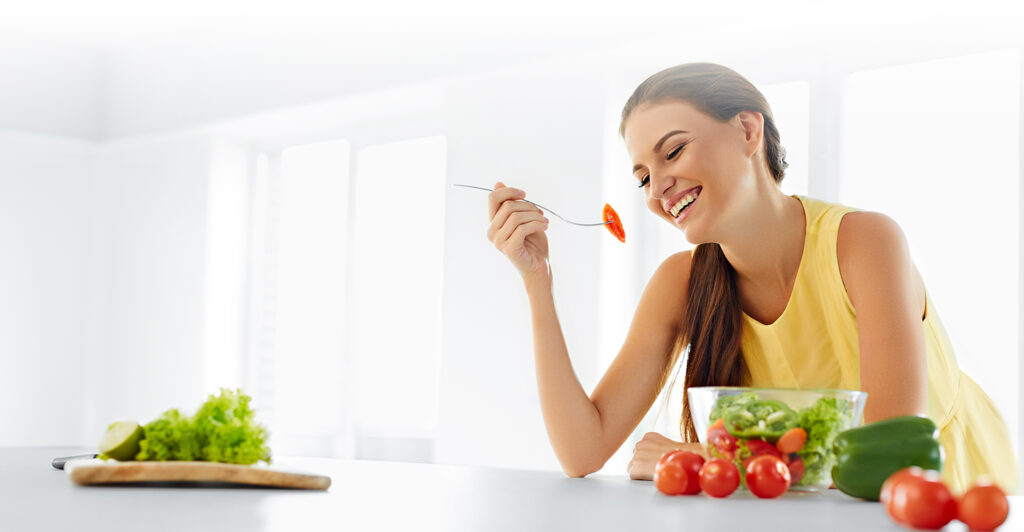 Persona preparando una ensalada con alimentos naturales para una dieta antiinflamatoria